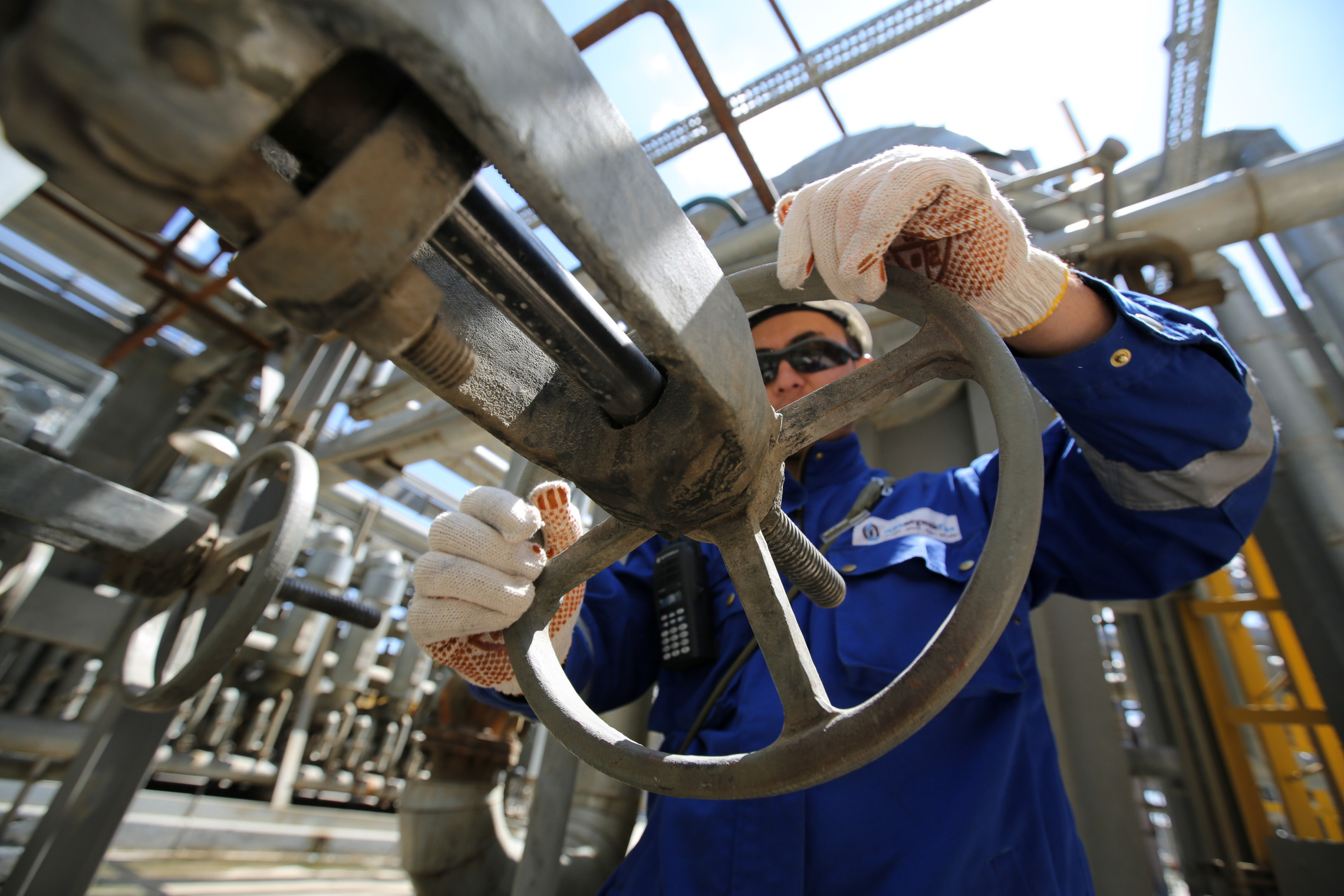 A worker operates a control valve on pipework at the Atyrau oil refinery, operated by KazMunaiGas National Co., in Atyrau, Kazakhstan, on Thursday, July 2, 2015.  Photographer: Andrey Rudakov/Bloomberg