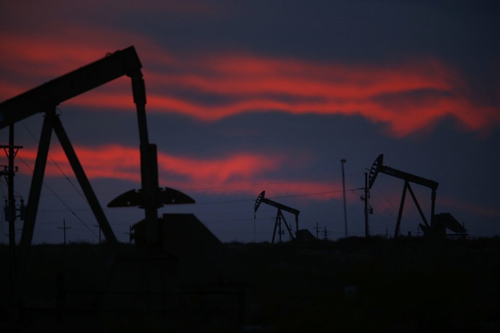 The silhouettes of electric oil pump jacks are seen at dusk in the oil fields surrounding Midland, Texas, U.S. Photographer: Luke Sharrett/Bloomberg