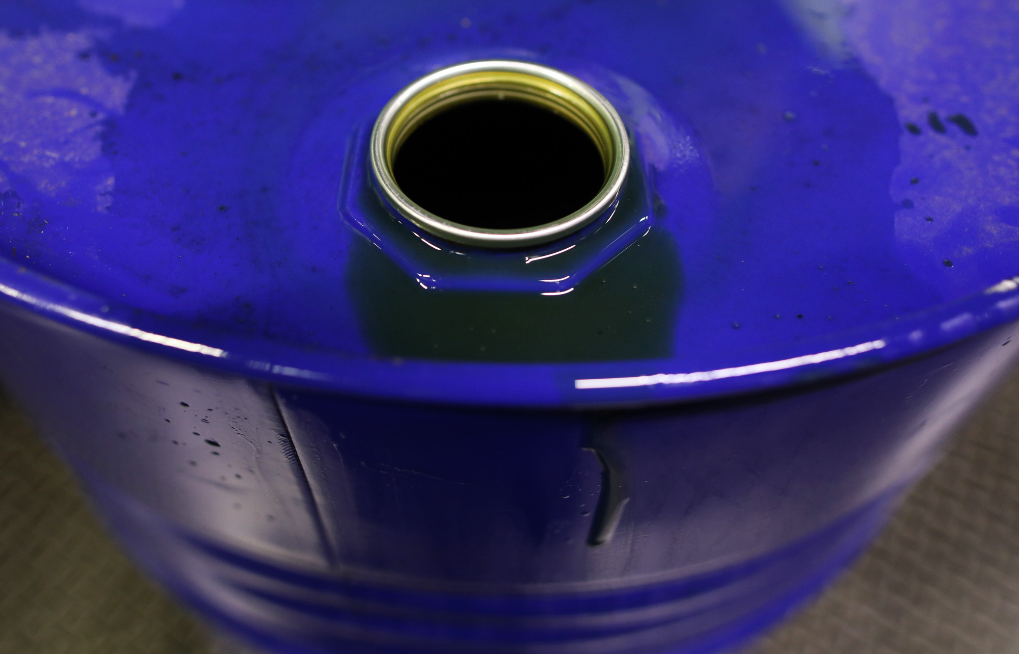 Excess fluid sits on the rim of a barrel of oil based lubricant at Rock Oil Ltd.'s factory in Warrington, U.K., on Monday, March 13, 2017. Oil declined after Saudi Arabia told OPEC it raised production back above 10 million barrels a day in February, reversing about a third of the cuts it made the previous month. Photographer: Chris Ratcliffe/Bloomberg