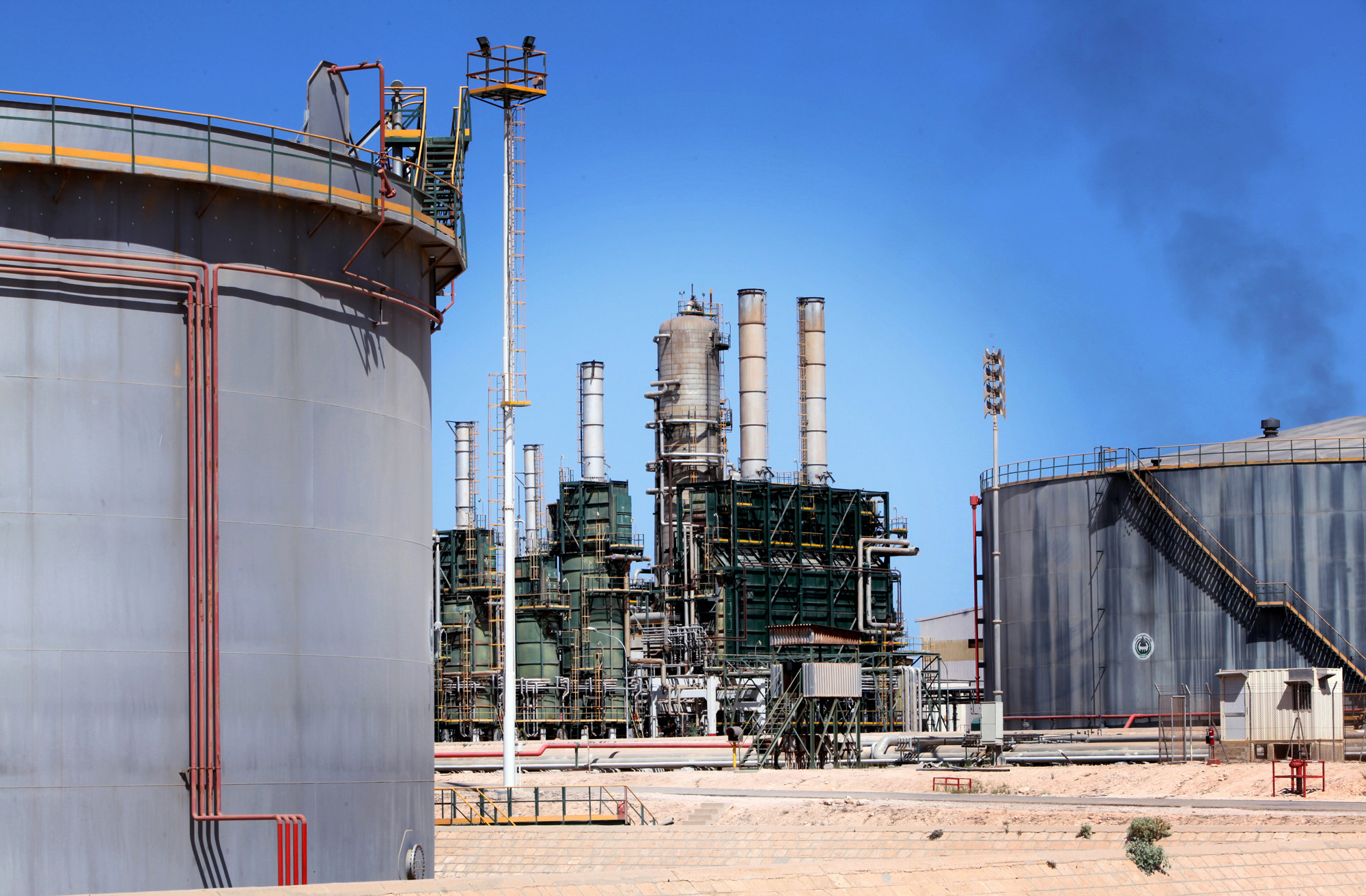 Refining towers and fuel storage tanks are seen at the Zawiya oil refinery near Tripoli, Libya, on Monday, Aug. 29, 2011.  Photographer: Shawn Baldwin/Bloomberg