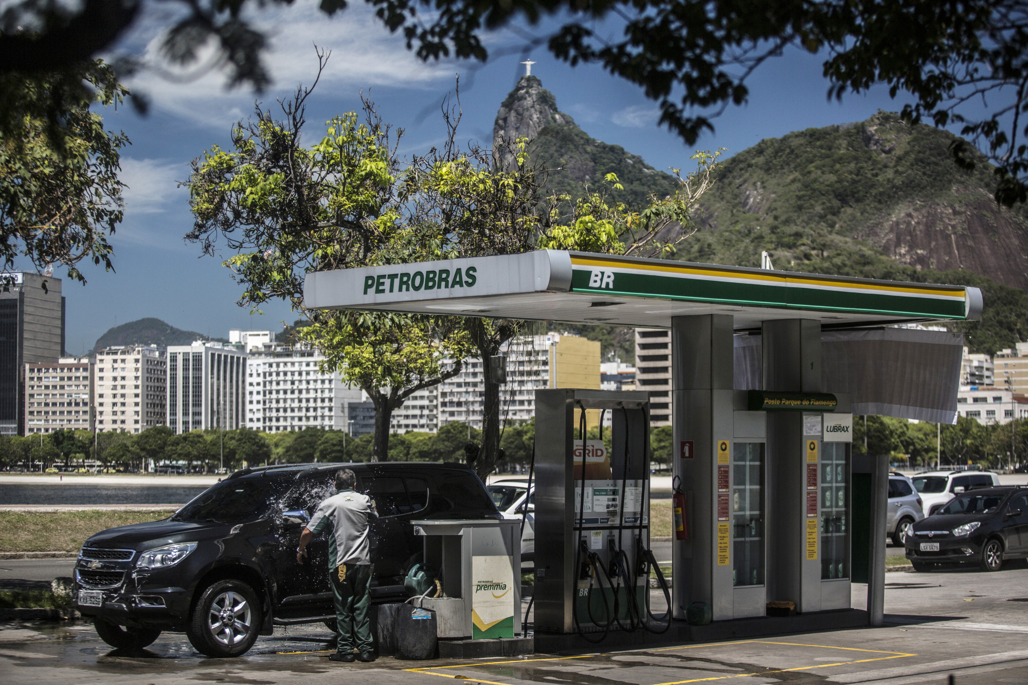 An attendant washes a car at a Petroleo Brasileiro SA (Petrobras) gas station