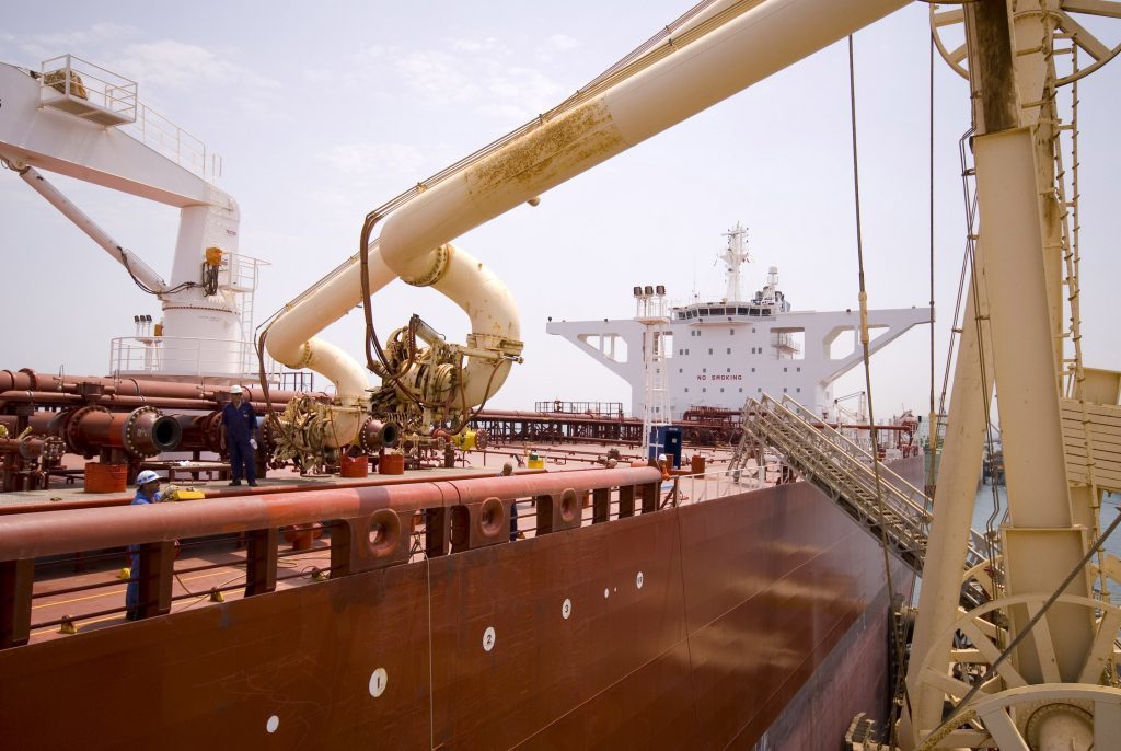 An Iraqi oil worker moves a second loading boom into place on an oil tanker that just arrived to load up with Iraqi crude oil at Al Basra oil terminal in the Northern Arabian Gulf. Photographer: CHARLES CROWELL/Bloomberg