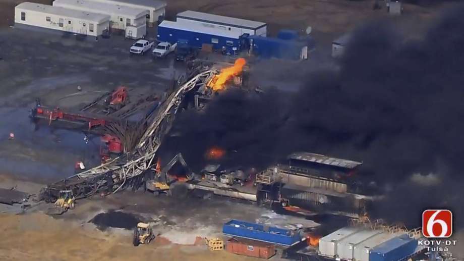 In this photo provided from a frame grab from Tulsa's KOTV/NewsOn6.com, fires burn at an eastern Oklahoma drilling rig near Quinton, Okla., Monday Jan. 22, 2018. Five people are missing after a fiery explosion ripped through a drilling rig, sending plumes of black smoke into the air and leaving a derrick crumpled on the ground, emergency officials said. (Christina Goodvoice, KOTV/NewsOn6.com via AP