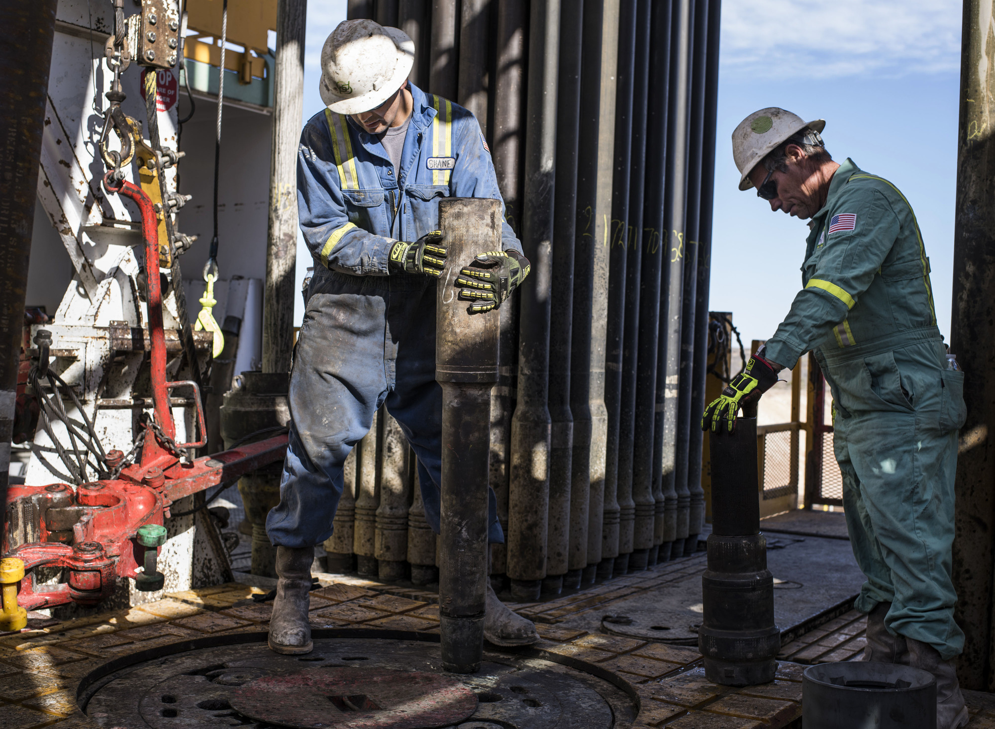 Precision Drilling oil rig operators install a bit guide on the floor of a Royal Dutch Shell Plc oil rig near Mentone, Texas, U.S. Photographer: Matthew Busch/Bloomberg