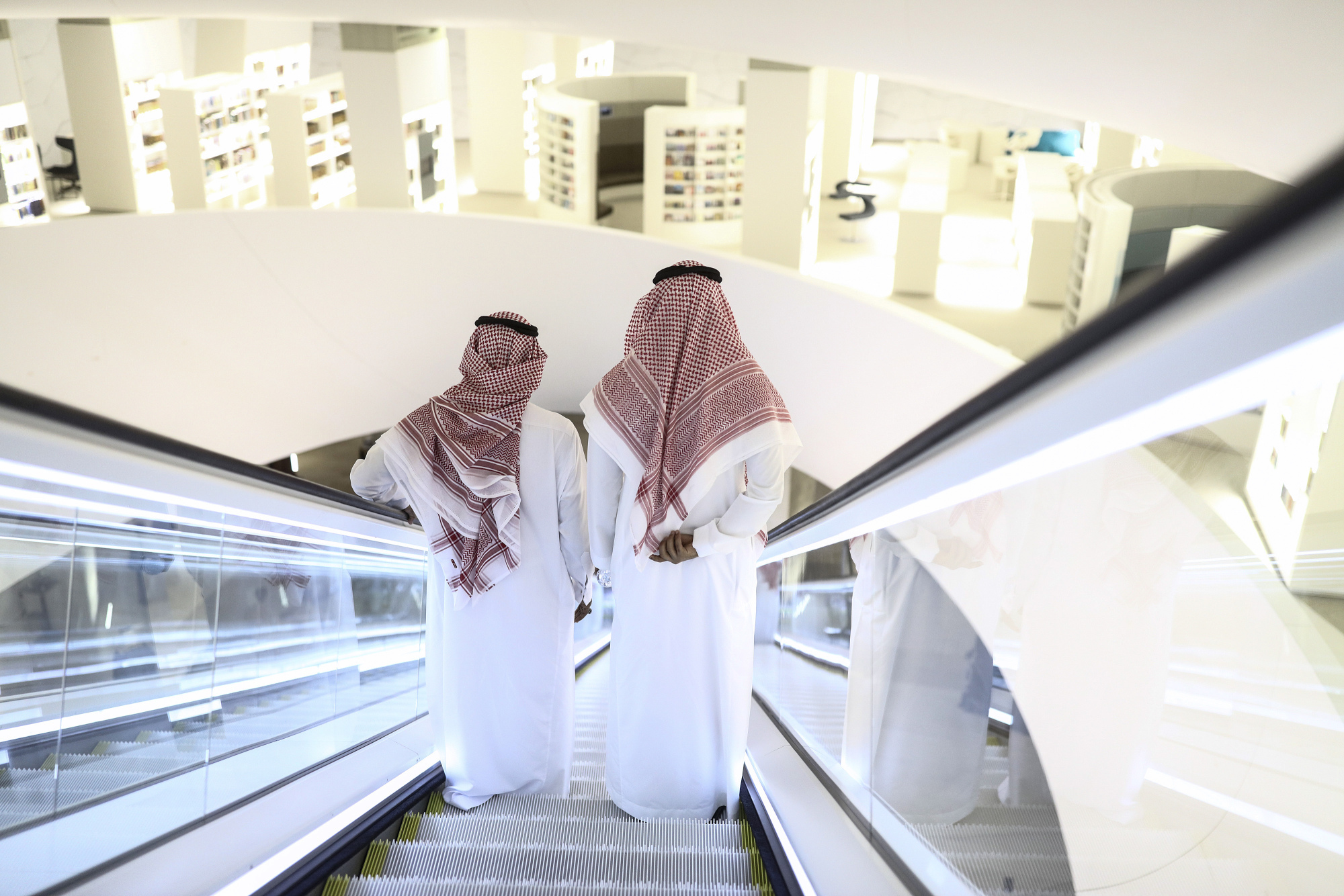 Attendees stand on an escalator as they move through the interior of the King Abdulaziz Center for World Culture during a tour of the project in Dhahran, Saudi Arabia, on Friday, Nov. 25, 2016. When completed, the project designed for the Saudi Arabian Oil Co. (Aramco) will contain diverse cultural facilities, including an auditorium, cinema, library, exhibition hall, museum and archive. Photographer: Simon Dawson/Bloomberg