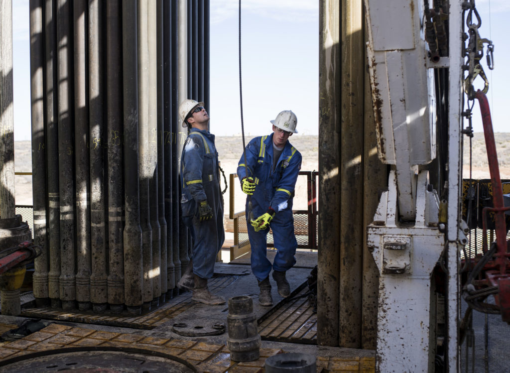 Precision Drilling oil rig operators prepare to install a bit guide on the floor of a Royal Dutch Shell Plc oil rig near Mentone, Texas, U.S., on Thursday, March 2, 2017.  Photographer: Matthew Busch/Bloomberg