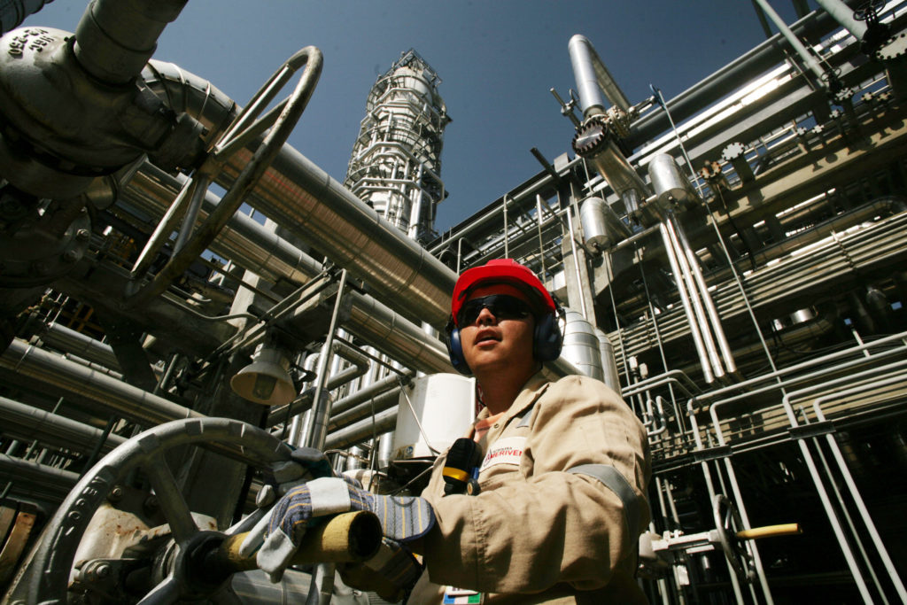 A worker opens a valve at the Ameriven oil refinery, one of the four companies at the Jose Complex in Anzoategui state, 200 miles East from Caracas, Venezuela, on Thursday, Sept. 13, 2007.  Photographer: DIEGO GIUDICE/Bloomberg