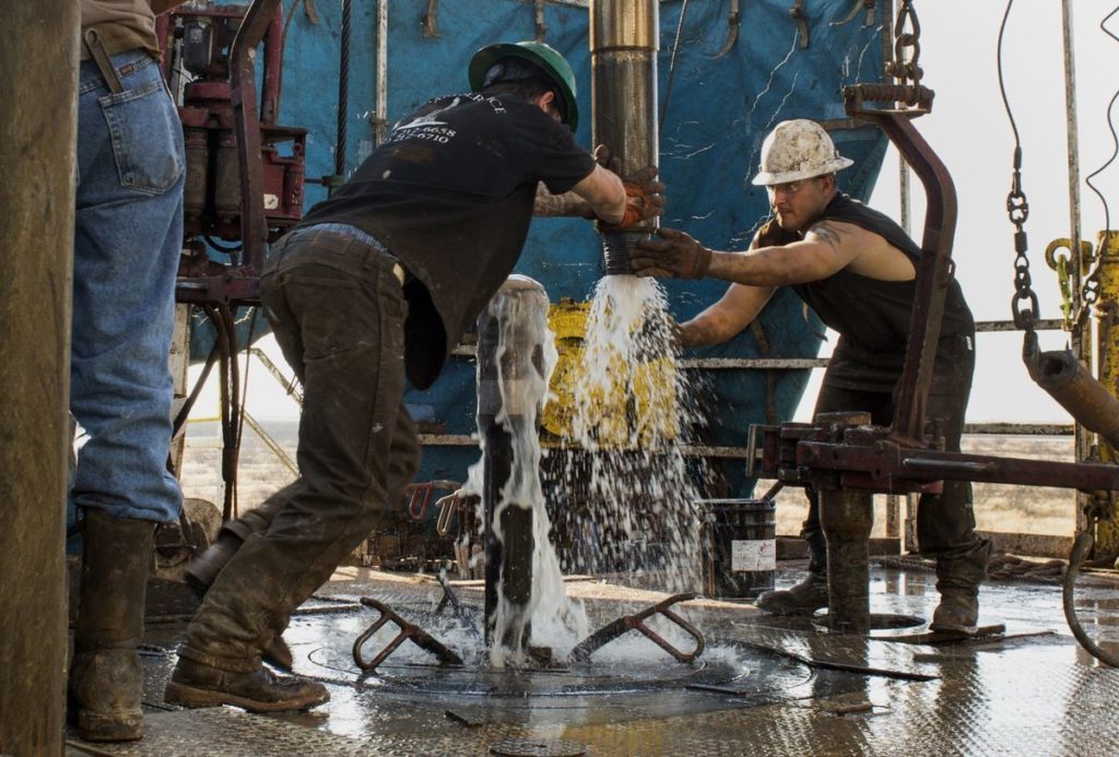 Workers connect drill bits and drill collars, used to extract natural petroleum, on Endeavor Energy Resources LP's Big Dog Drilling Rig 22 in the Permian basin outside of Midland, Texas, U.S. Photographer: Brittany Sowacke/Bloomberg