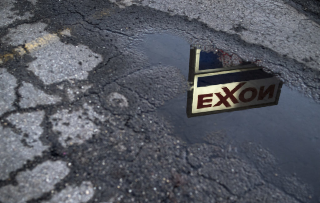 Exxon Mobil Corp. signage is reflected in a puddle at a gas station in Nashport, Ohio, U.S., on Friday, Jan. 26, 2018. Photographer: Ty Wright/Bloomberg