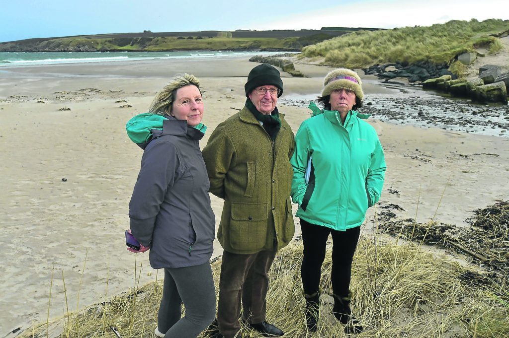 Sandend residents, from left, Tina Wilson, Ray Murray and Jane Winfield look over the area where the cables could come in