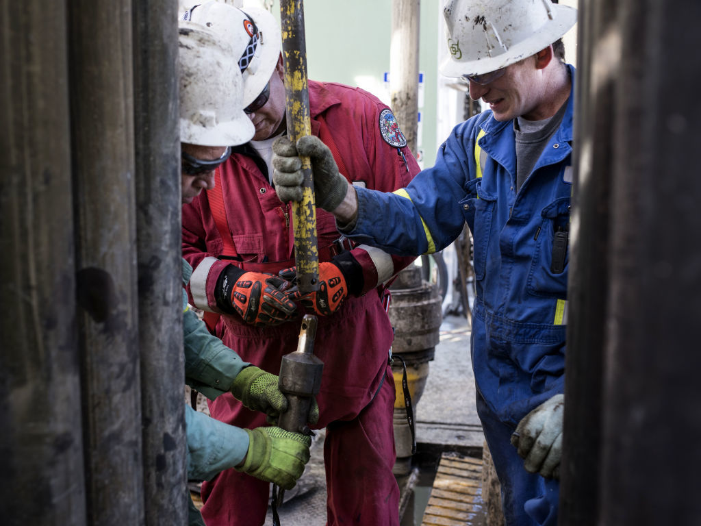 Precision Drilling oil rig operators install a bit guide on the floor of a Royal Dutch Shell Plc oil rig near Mentone, Texas, U.S., on Thursday, March 2, 2017. Exxon Mobil Corp., Royal Dutch Shell and Chevron Corp., are jumping into American shale with gusto, planning to spend a combined $10 billion this year, up from next to nothing only a few years ago. Photographer: Bloomberg/Bloomberg