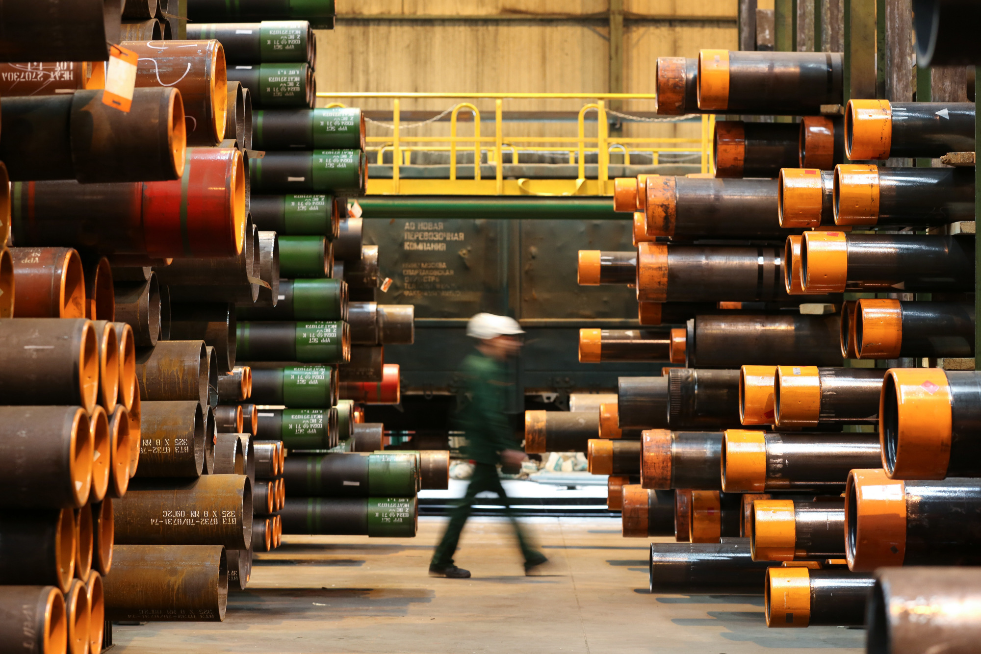 A worker passes stores of seamless steel pipes for use in oil and gas pipelines in a storage area at the Volzhsky Pipe Plant OJSC, operated by TMK PJSC, in Volzhsky, Russia, on March 30, 2017.  Photographer: Andrey Rudakov/Bloomberg