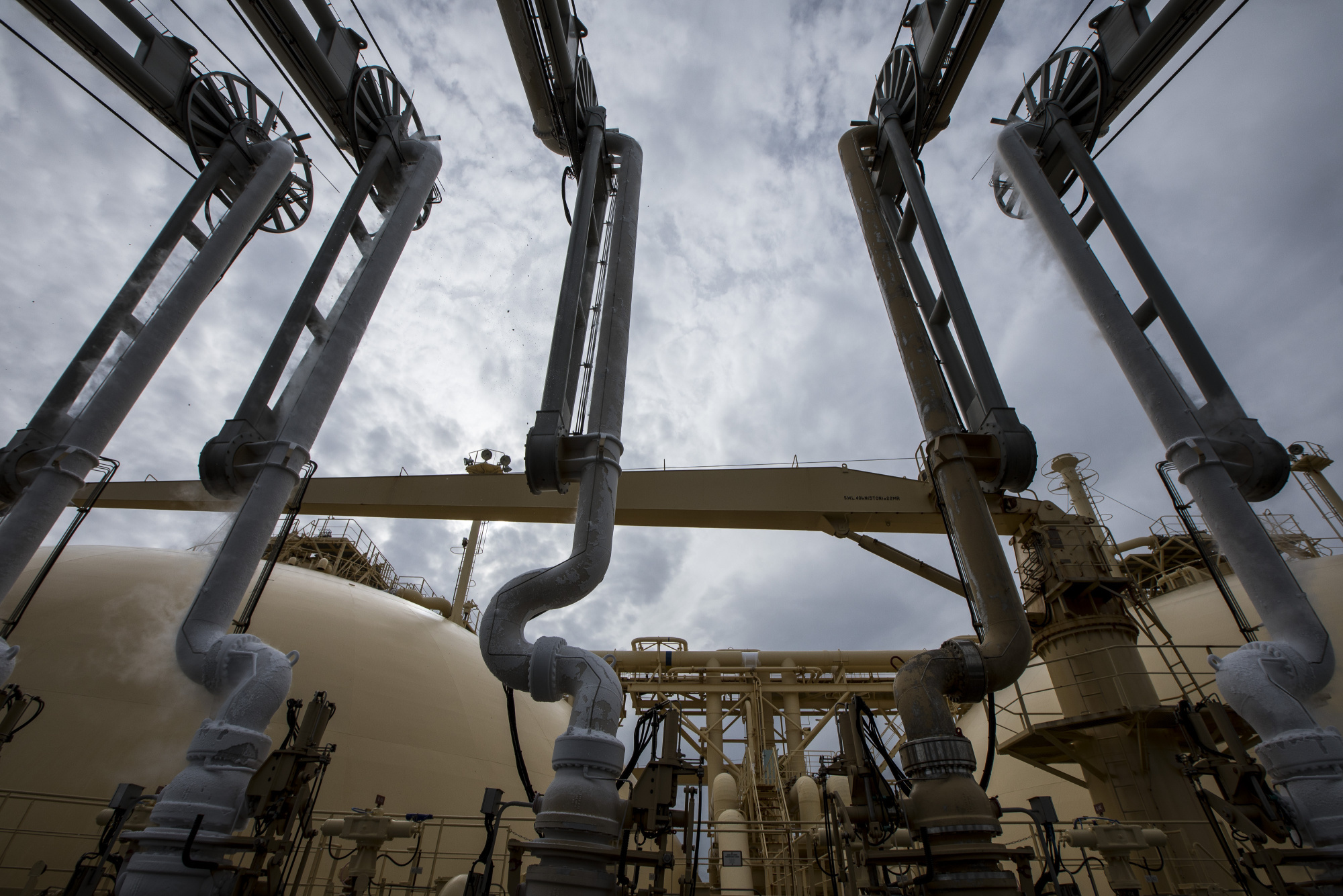 Liquefied natural gas (LNG) dispenses through pipes on-board the Gallina LNG tanker after docking at the National Grid Plc's Grain LNG plant on the Isle of Grain in Rochester, U.K. Photographer: Jason Alden/Bloomberg