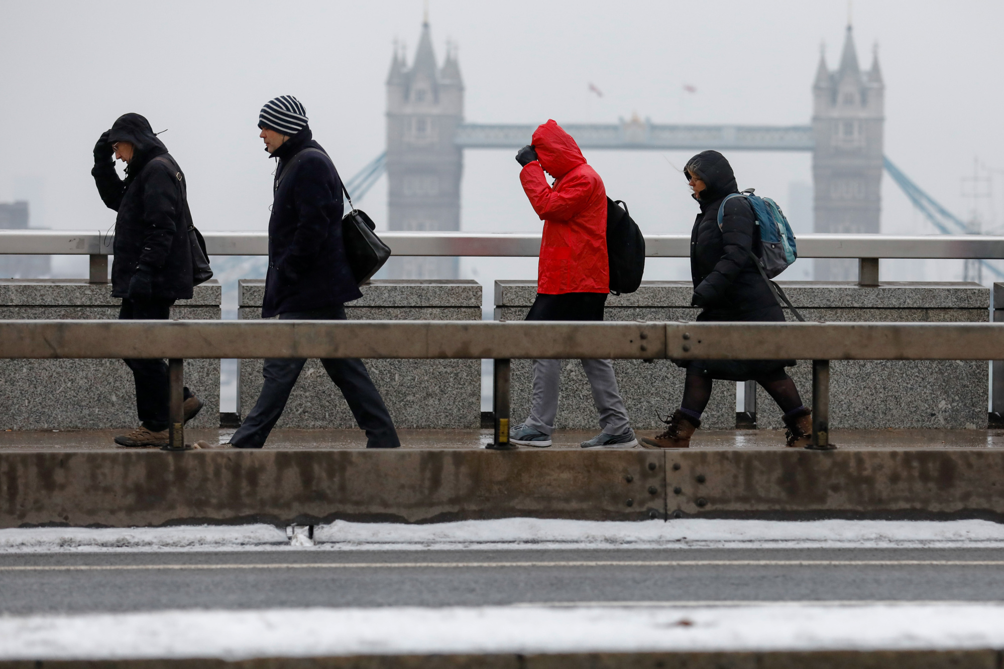 Commuters make their way across London Bridge in the snow in London, U.K., on Thursday, March 1, 2018.  Photographer: Luke MacGregor/Bloomberg