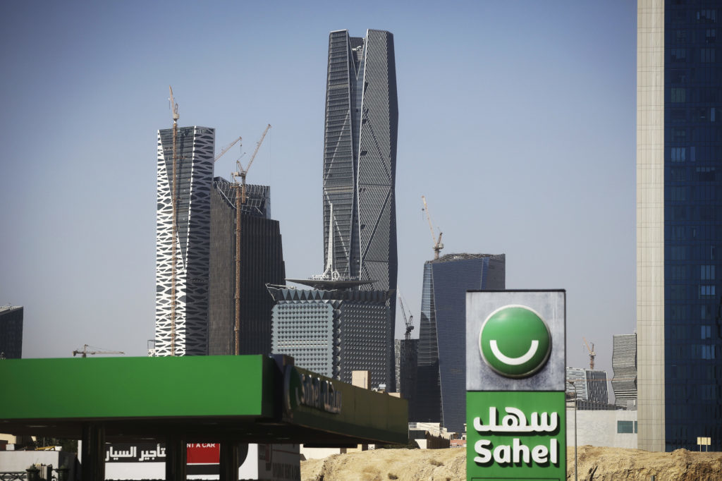 A Sahel petrol station, operated by Tashelat Marketing Co Ltd., stands in front of buildings under construction including offices, apartments, hotels, conference centres, mosque and entertainment venues, at the King Abdullah Financial District (KAFD)in Riyadh, Saudi Arabia, on Thursday, Dec. 1, 2016. The King Abdullah Financial District, known as the KAFD and about 70 percent complete, has been beset by construction delays since work began in the Saudi capital in 2006. Photographer: Simon Dawson/Bloomberg