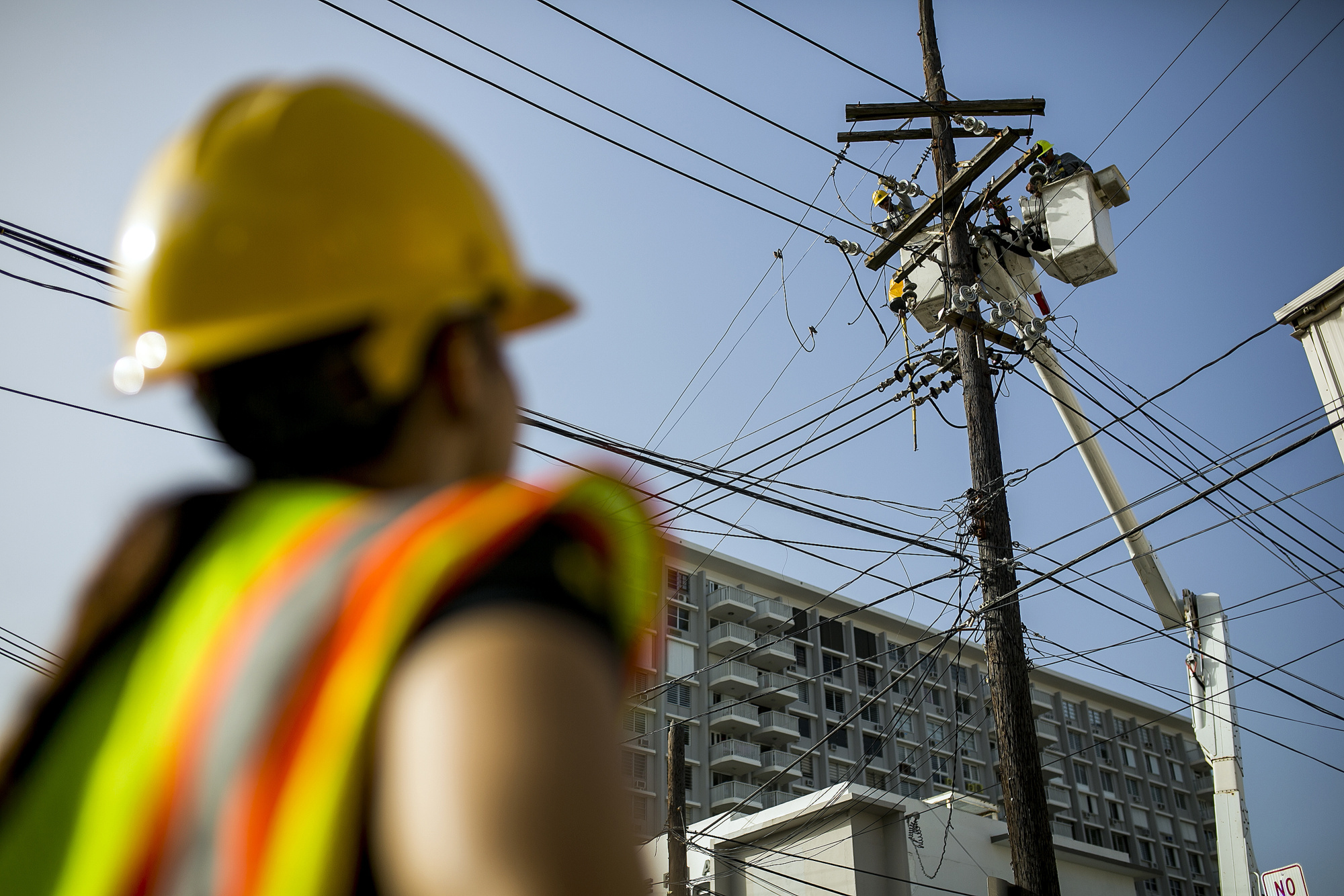 Puerto Rico Electric Power Authority (PREPA) employees fix power lines in Santurce, San Juan, Puerto Rico, on Thursday, Oct. 19, 2017. For longer than most can remember, Puerto Ricans have paid some of the highest energy costs in the U.S. to a notoriously unreliable utility that neglected their grid for years and runs fossil-fuel plants that may be damaging their lungs. A month after Hurricane Maria devastated the island, power lines still lay slack along roads, utility poles are snapped clean in half, and most Puerto Ricans remain in the dark. Photographer: Xavier Garcia/Bloomberg