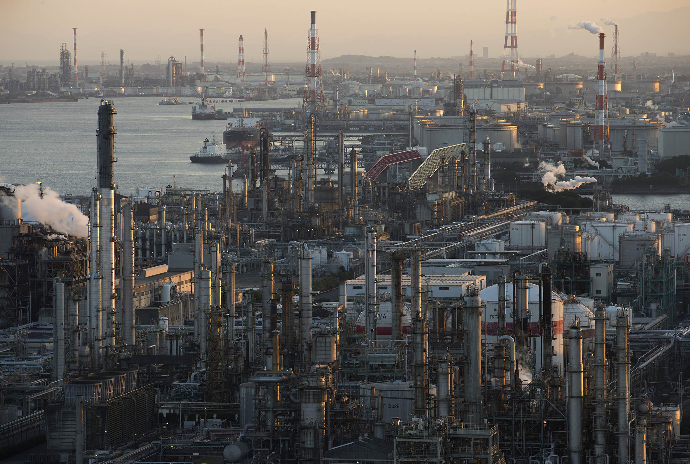 Chemical plants and oil refineries stand at the Yokkaichi industrial complex at dusk in Yokkaichi, Mie Prefecture, Japan, on Friday, Oct. 27, 2016. The Paris Agreement, the most sweeping climate change agreement to combat global warming to date, will enter into force Nov. 4. Photographer: Tomohiro Ohsumi/Bloomberg