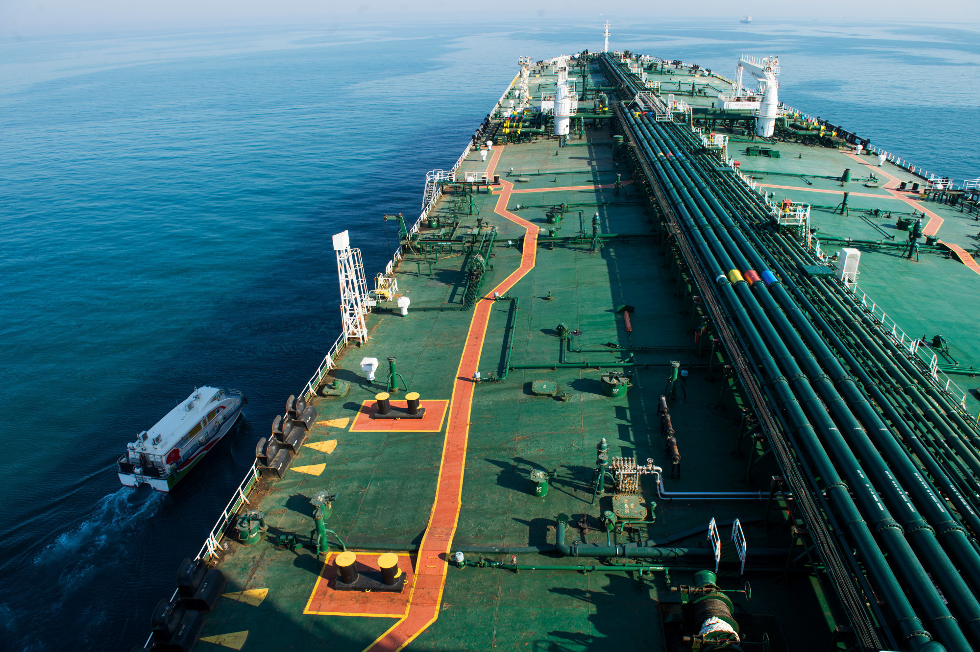 A support vessel sails alongside the crude oil tanker 'Devon' as it sails through the Persian Gulf towards Kharq Island oil terminal to transport crude oil to export markets in Bandar Abbas, Iran, on Friday, March 23, 2018. Geopolitical risk is creeping back into the crude oil market. Photographer: Ali Mohammadi/Bloomberg