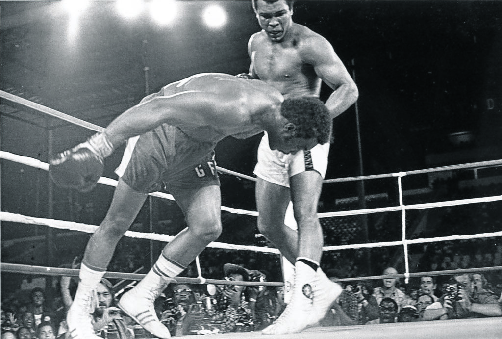 Challenger Muhammad Ali watches as defending world champion George Foreman goes down to the canvas in the eighth round of their WBA/WBC championship match in Kinshasa, Zaire, on Oct. 30, 1974.