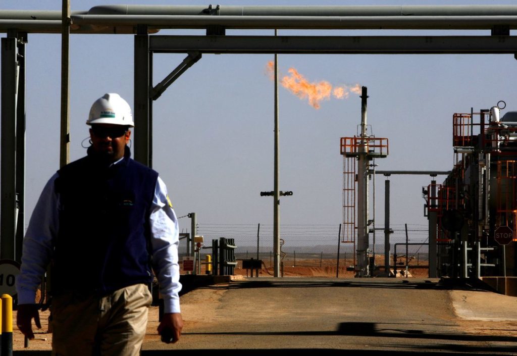 ALGERIA - DECEMBER 14: An employee walks in front of a gas flare at the In Salah Gas (ISG) Krechba Project, run by Sonatrach, British Petroleum (BP), and StatoilHydro, in the Sahara desert near In Salah, Algeria, on Sunday, Dec. 14, 2008. From produced gas, the carbon capture plant, the largest and first of its kind, removes annually the carbon dioxide emissions equivalent of 200,000 automobiles running 30,000 kilometers. The CO2 is then reinjected into a two-kilometer deep reservoir instead of the atmosphere, with the intention of storing it perpetually. (Photo by Adam Berry/Bloomberg via Getty Images)