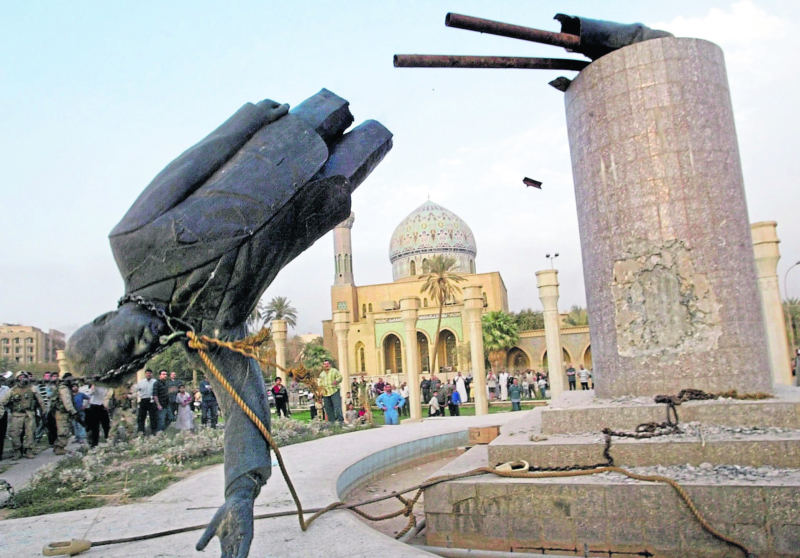 A statue of Iraq’s President Saddam Hussein falls in central Baghdad April 9, 2003, pulled down by US troops.