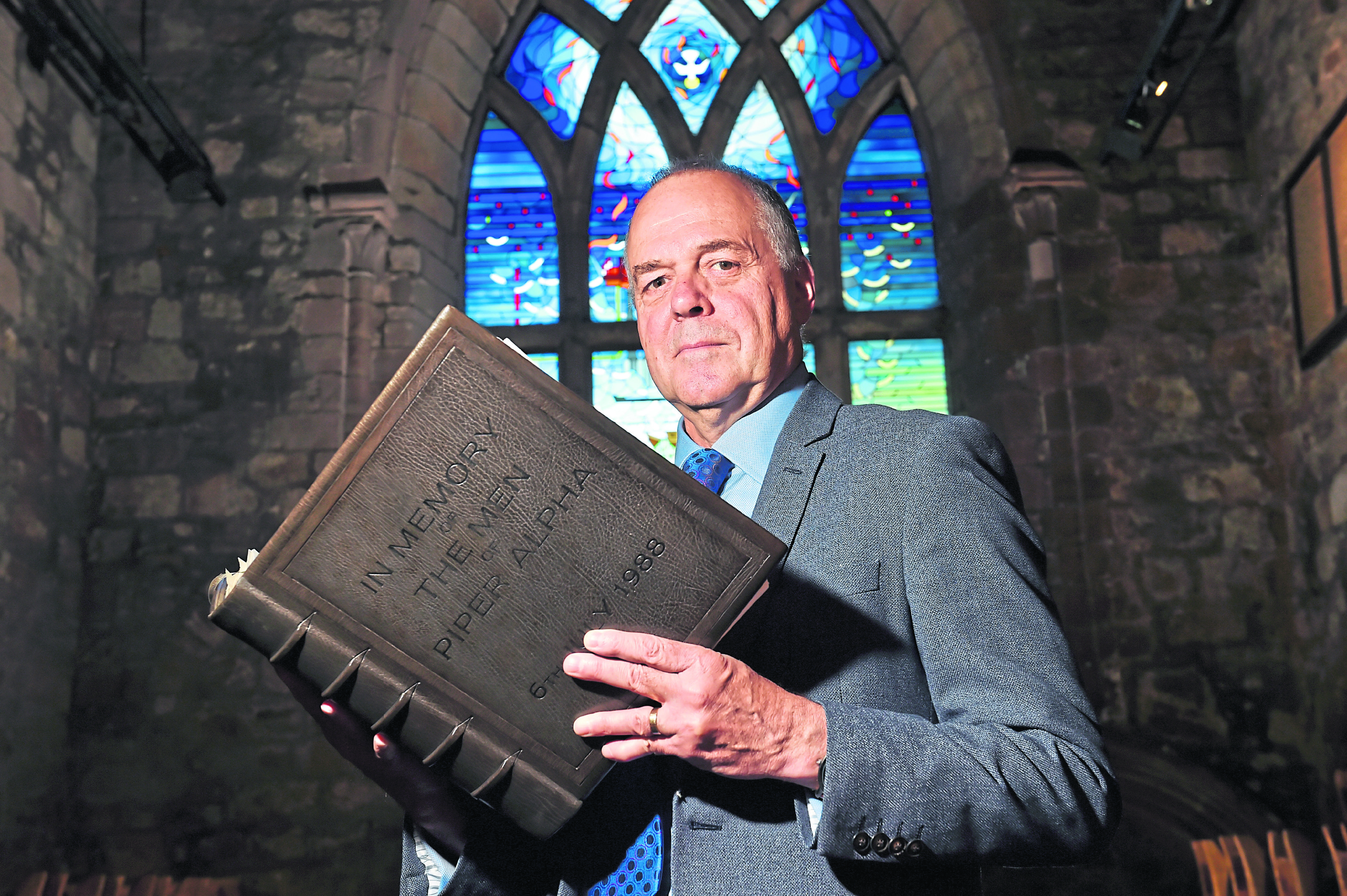 Reverend Gordon Craig, with Piper Alpha book of rememberance at Kirk of St Nicolas.