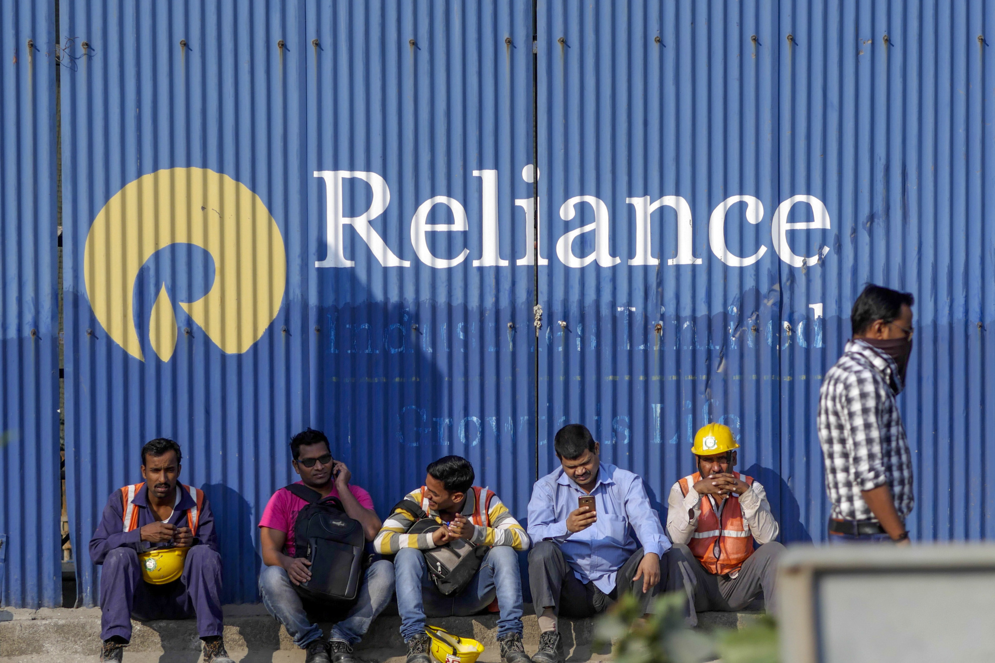 Laborers sit outside a Reliance Industries construction site at the Bandra Kurla Complex in Mumbai, India, on Sunday, Jan. 28, 2018. India's economy is expected to grow at 6.75 percent this year on the back of a recovery in second half of the year, Chief Economic Adviser Arvind Subramanian said in the Economic Survey presented in Parliament on Nov. 29. Photographer: Dhiraj Singh/Bloomberg