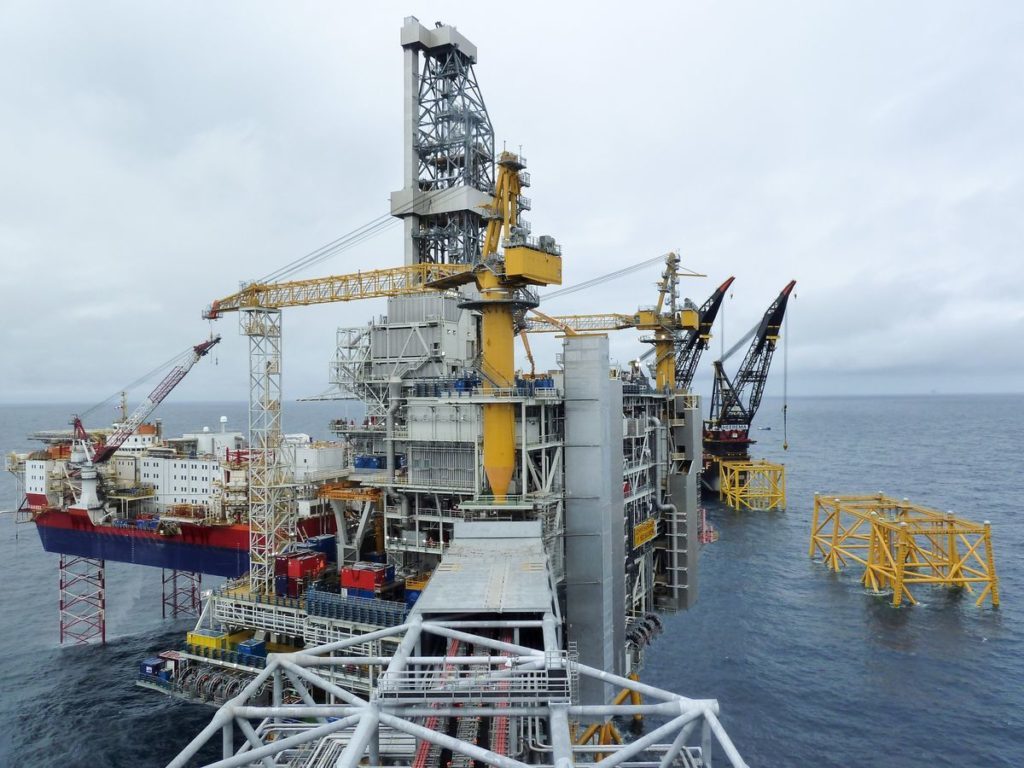 The Johan Sverdrup drilling platform, operated by Equinor ASA, center, and the Haven jack-up accommodation rig, operated by Jacktel AS, a unit of Master Marine AS, stand in the Johan Sverdrup offshore oil field, about 160 kilometers (100 miles) west of Norways oil capital, Stavanger, Norway, on Wednesday, Aug. 22, 2018. When Sverdrup reaches maximum production of 660,000 barrels a day by the middle of the next decade, it will make up about 40 percent of the countrys total oil and gas output, according to Equinor ASA. Photographer: Mikael Holter/Bloomberg