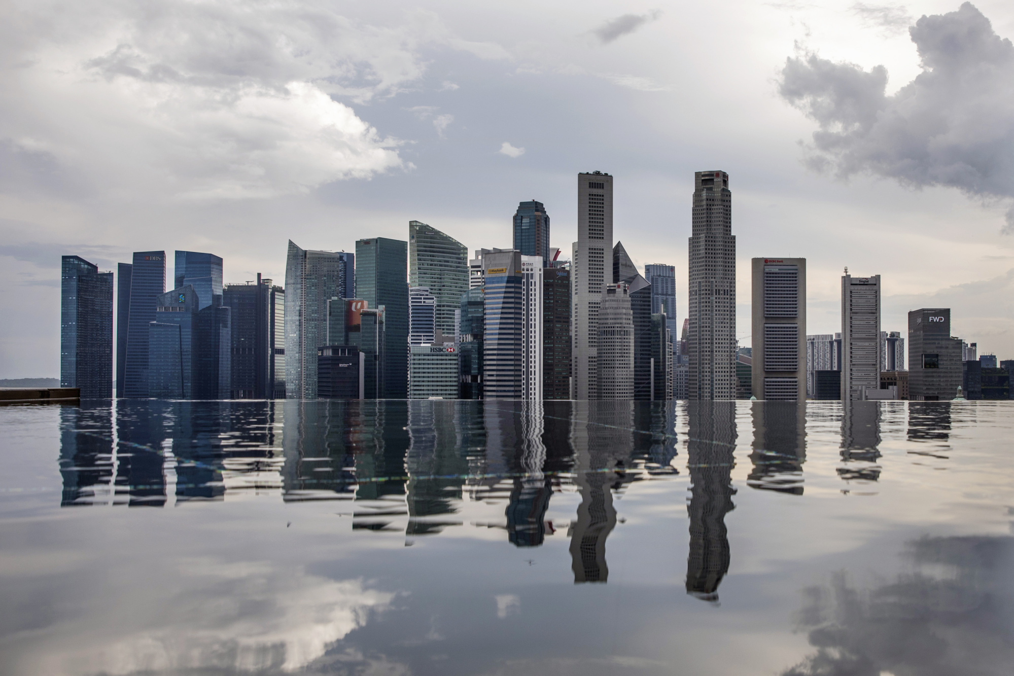 Commercial buildings standing in the central business district are reflected in a rooftop pool in Singapore, on Wednesday, June 13, 2018. 
Photographer: Brent Lewin/Bloomberg