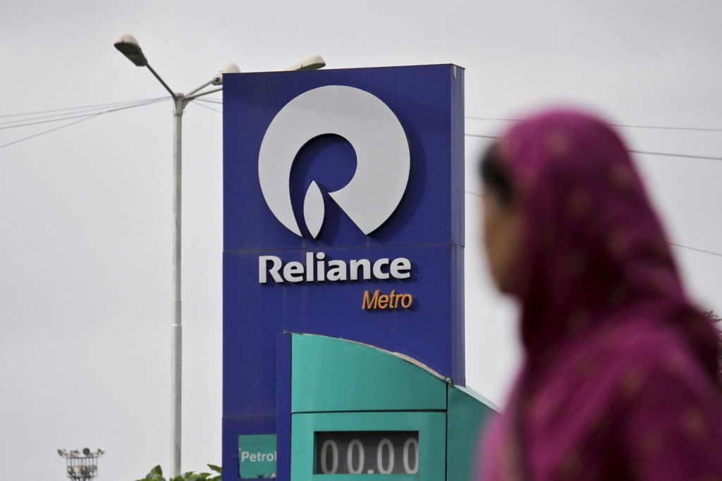 A woman walks past a Reliance Industries Ltd. gas station in Mumbai, India, on Thursday, July 19, 2012.  Photographer: Dhiraj Singh/Bloomberg