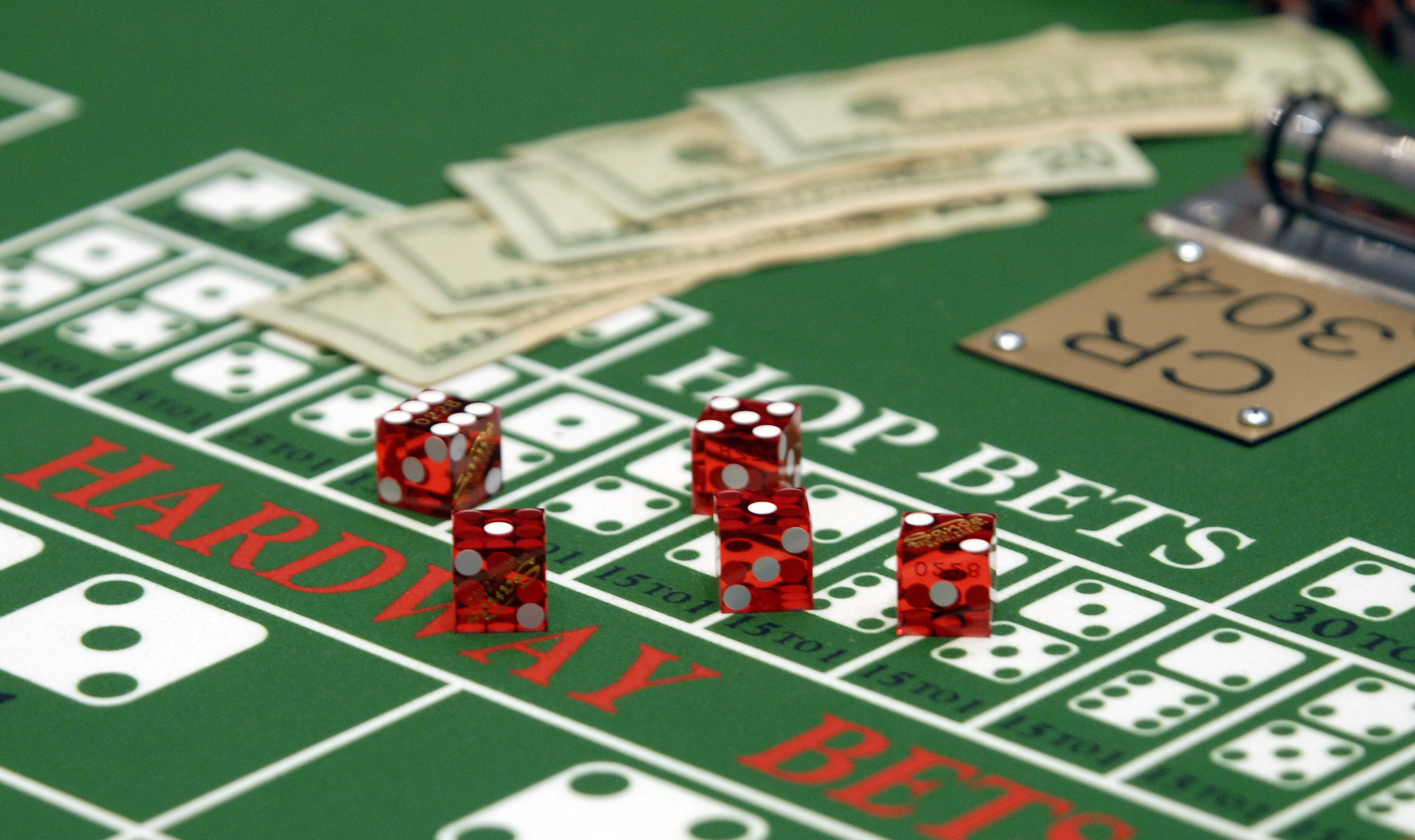 Cash and dice sit on a craps table at the Sands Casino Resort in Bethlehem, Pennsylvania, U.S. Photographer: Bradley C. Bower/Bloomberg