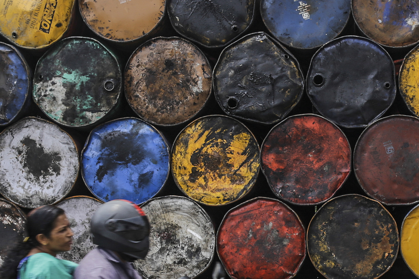 India's ONGC needs to pump more oil: a motorcyclist drives past empty stacked oil drums in Cochin, India, on Friday, May 29, 2015.  Photographer: Dhiraj Singh/Bloomberg