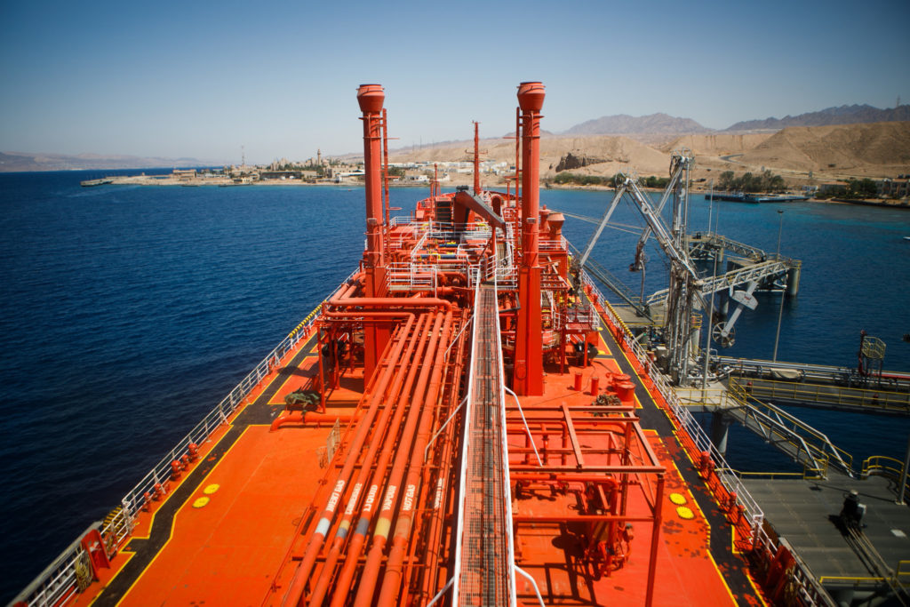 The 'Eugenia Gas' liquefied petroleum gas (LPG) tanker sits beside fuel transfer pipes at a terminal at Aqaba port, operated by Aqaba Development Corp., in Aqaba, Jordan, on Wednesday, April 11, 2018. Both the liquefied natural gas (LNG) and the LPG terminals were developed to secure the supply of gas resources after the disruption in Egyptian natural gas imports in 2010. Photographer: Annie Sakkab/Bloomberg