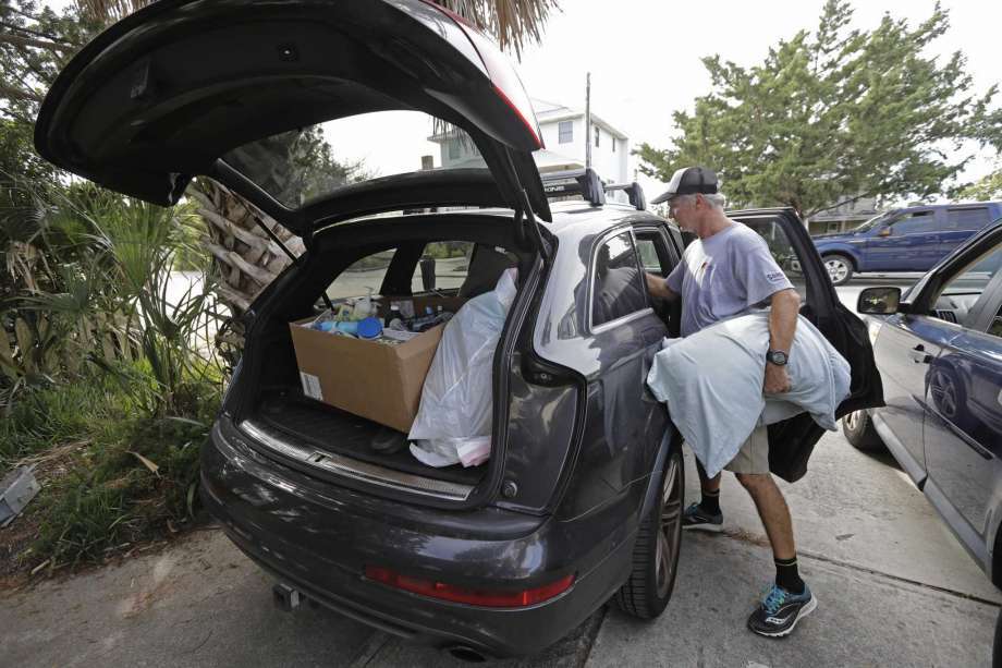 Jason Moore, of Raleigh, N.C., packs to evacuate from Wrightsville Beach, N.C., Wednesday, Sept. 12, 2018 as Hurricane Florence threatens the coast. (AP Photo/Chuck Burton)
