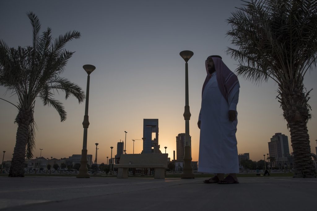 A man walks past palm trees lining the corniche promenade in Dhahran, Saudi Arabia, on Thursday, Oct. 4, 2018.