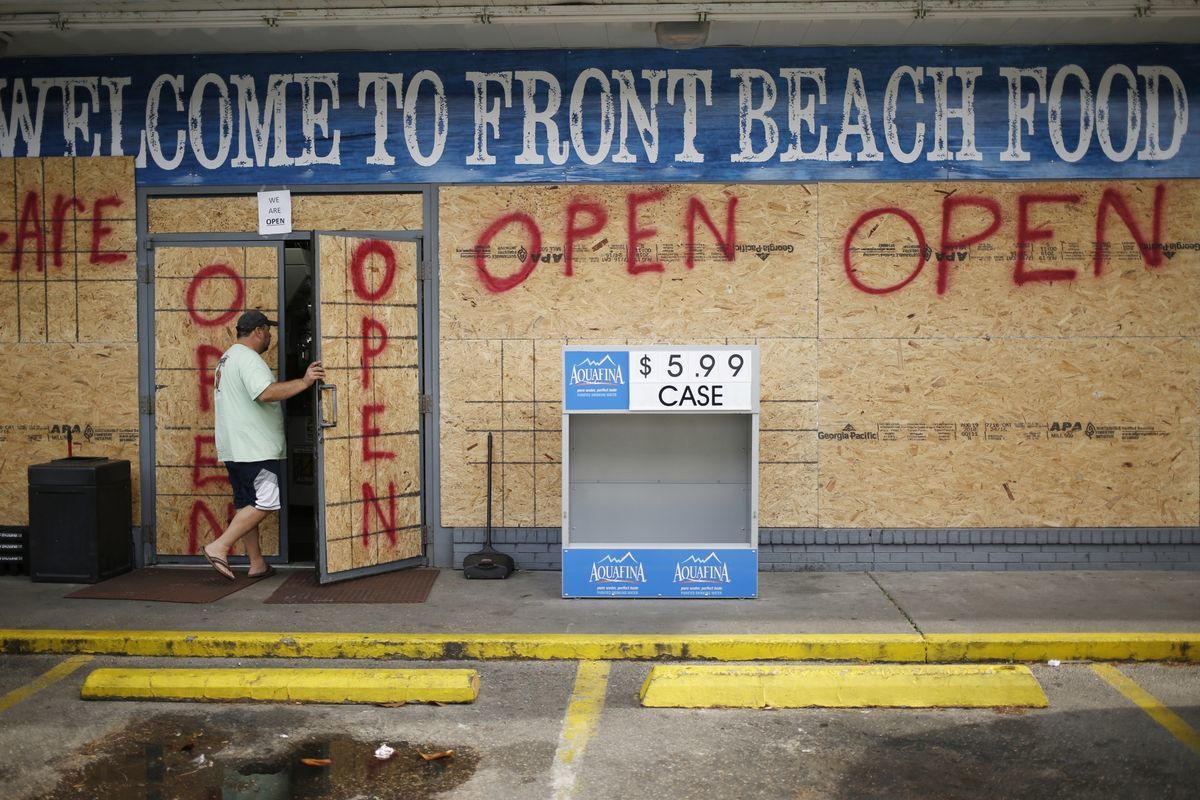 A customer enters a boarded up gas station in Panama City Beach, Florida Photographer: Luke Sharrett/Bloomberg