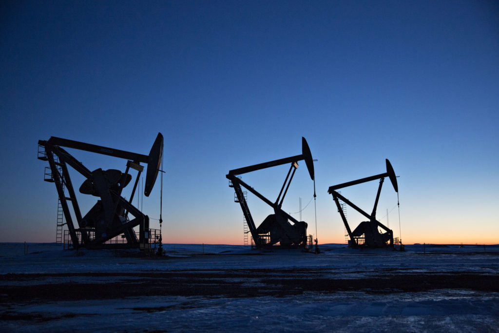 The silhouettes of pumpjacks are seen above oil wells in the Bakken Shale Formation near Dickinson, North Dakota, U.S., on Wednesday, March 7, 2018.