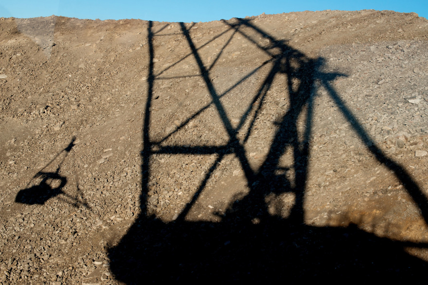 The shadow of a dragline excavator falls on oil shale during digging operations at Eesti Energia AS's open pit mine in Narva, Estonia. Photographer: Peter Kollanyi/Bloomberg
