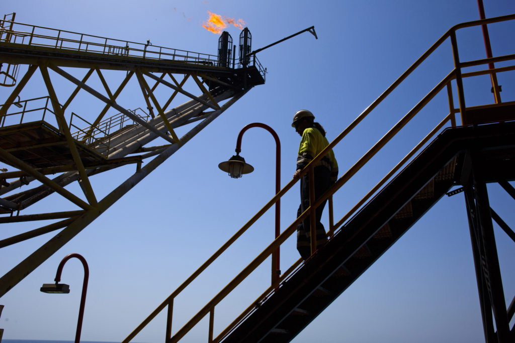 An oil worker passes the waste gas venting pipes on the Casablanca oil platform, operated by Repsol SA, in the Mediterranean Sea off the coast of Tarragona, Spain, on Tuesday, June 28, 2016.  Photographer: Angel Navarrete/Bloomberg