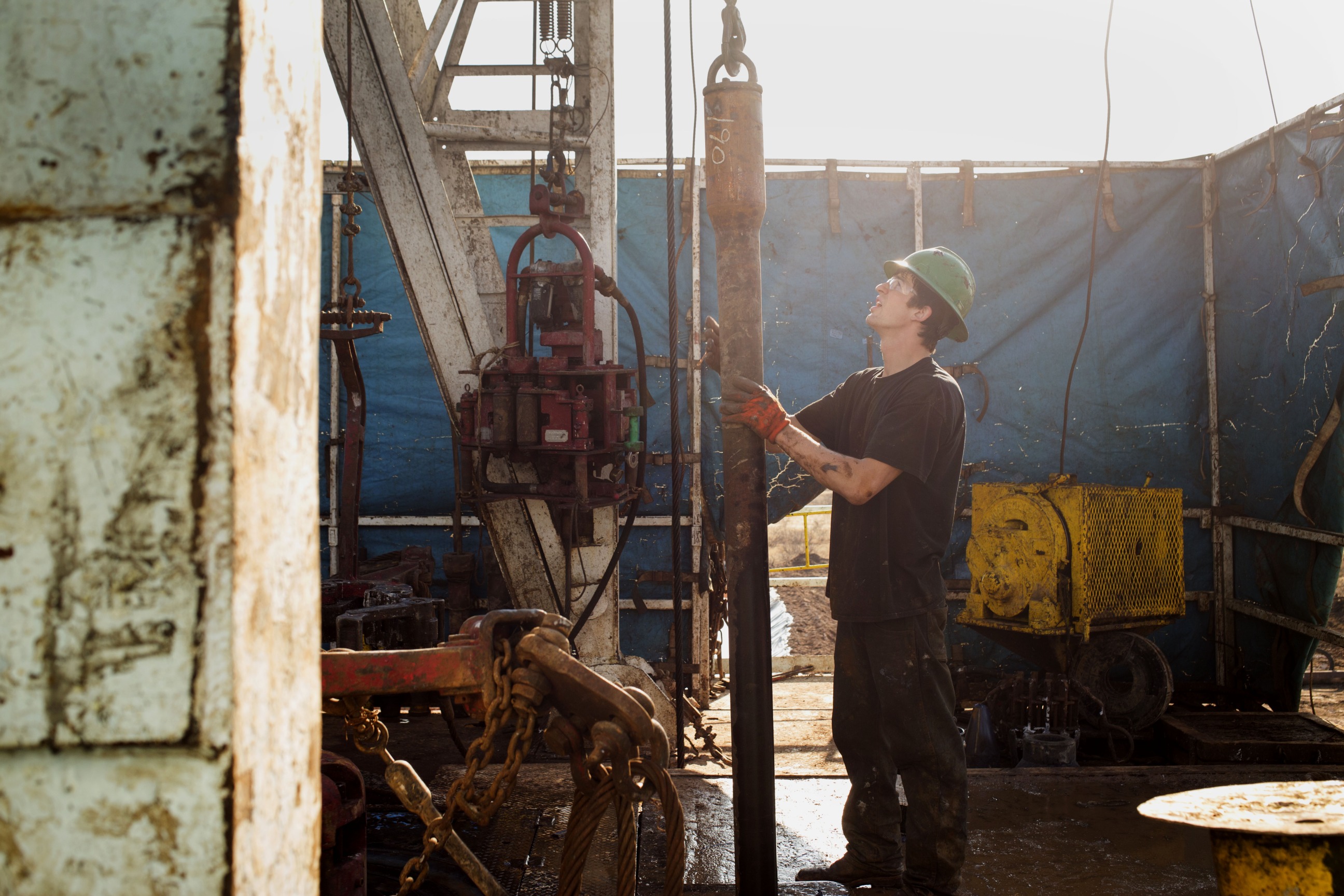 A worker checks the drilling rig before attaching it to the turntable on Endeavor Energy Resources LP's Big Dog Drilling Rig 22 in the Permian basin outside of Midland, Texas, U.S., on Friday, Dec. 12, 2014.  Photographer: Brittany Sowacke/Bloomberg