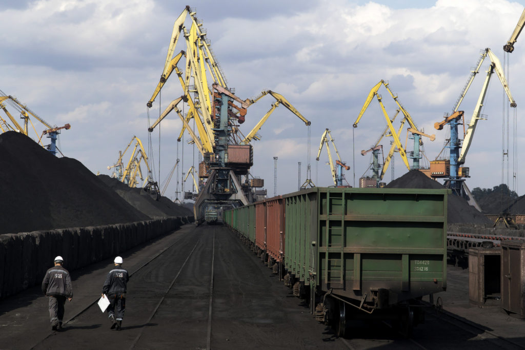 Workers pass freight wagons waiting to transport a shipment of coal from U.S. supplier at Yuzhny Port, near Odessa, Ukraine, in Sept. 2017. Photographer: Vincent Mundy/Bloomberg