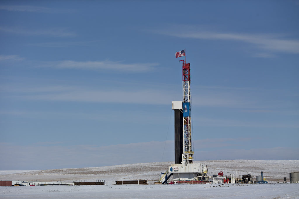 An American flag flies on top of a Unit Drilling Co. rig in the Bakken Formation outside Watford City, North Dakota, U.S., on Friday, March 9, 2018.  Photographer: Daniel Acker/Bloomberg