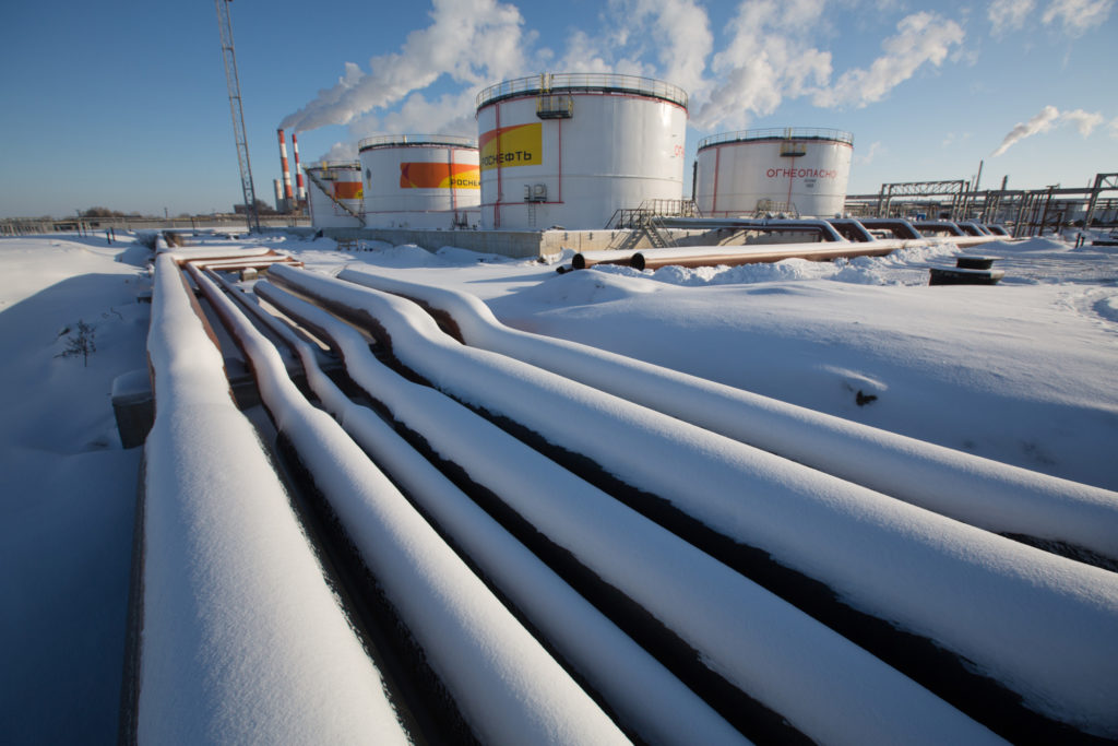 Oil pipelines and storage tanks stand in the snow at the Novokuibyshevsk oil storage plant, operated by Rosneft PJSC, in Novokuibyshevsk, Samara region, Russia, on Thursday, Dec. 22, 2016.  Photographer: Andrey Rudakov/Bloomberg