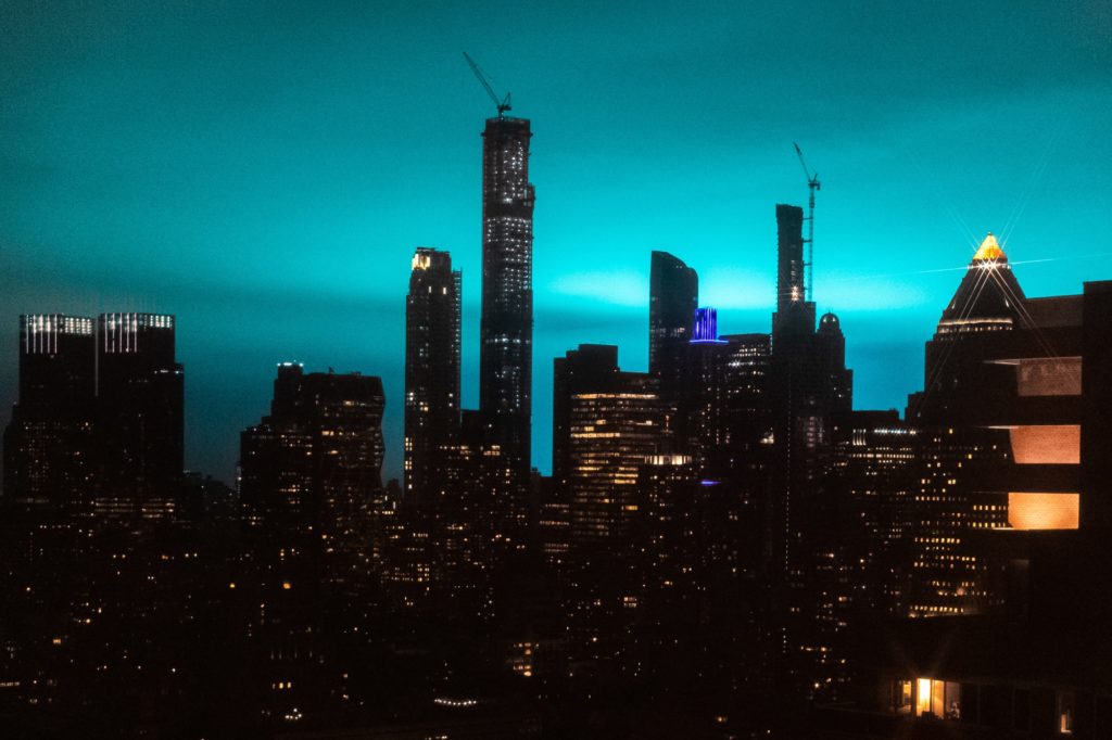 Buildings stand as the night sky is illuminated by blue light in New York on Dec. 27, 2018. Photographer: Jeenah Moon/Bloomberg