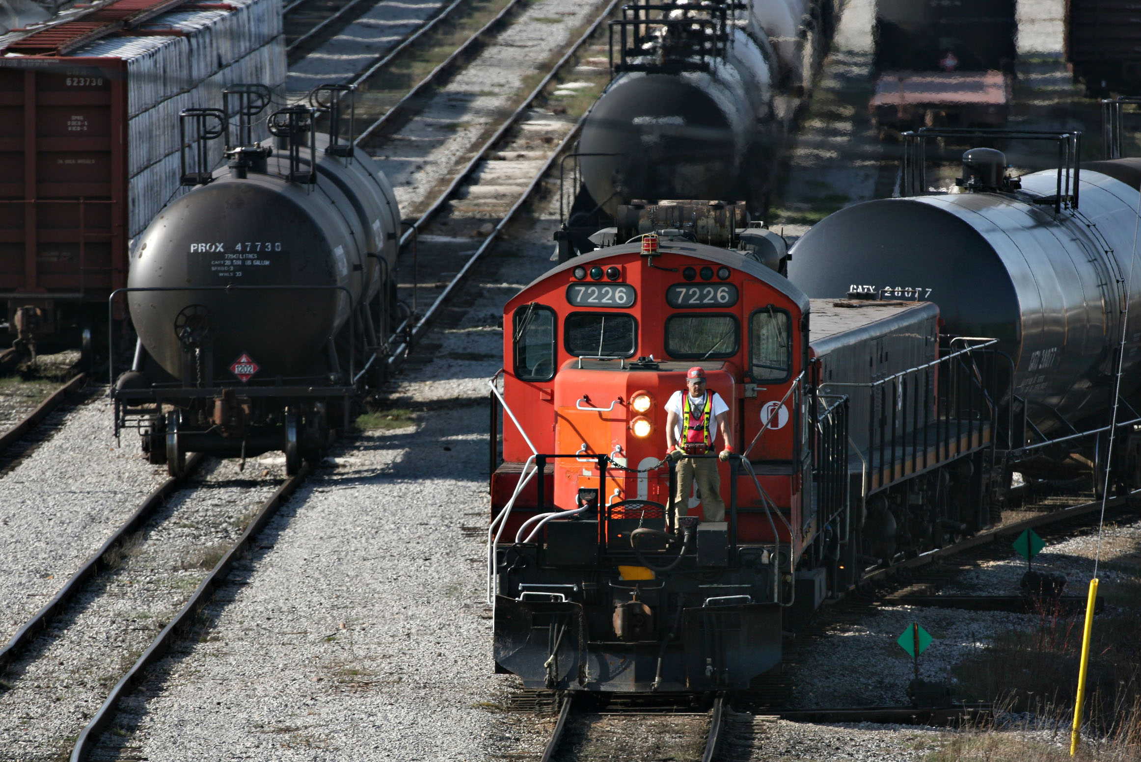 A railway worker stands in the front of a Canadian National Raliway Co. freight train as it moves through their Macmillan yard, north of Toronto, Ontario, Canada, Wednesday, April 19, 2006. Photographer: Norm Betts/Bloomberg