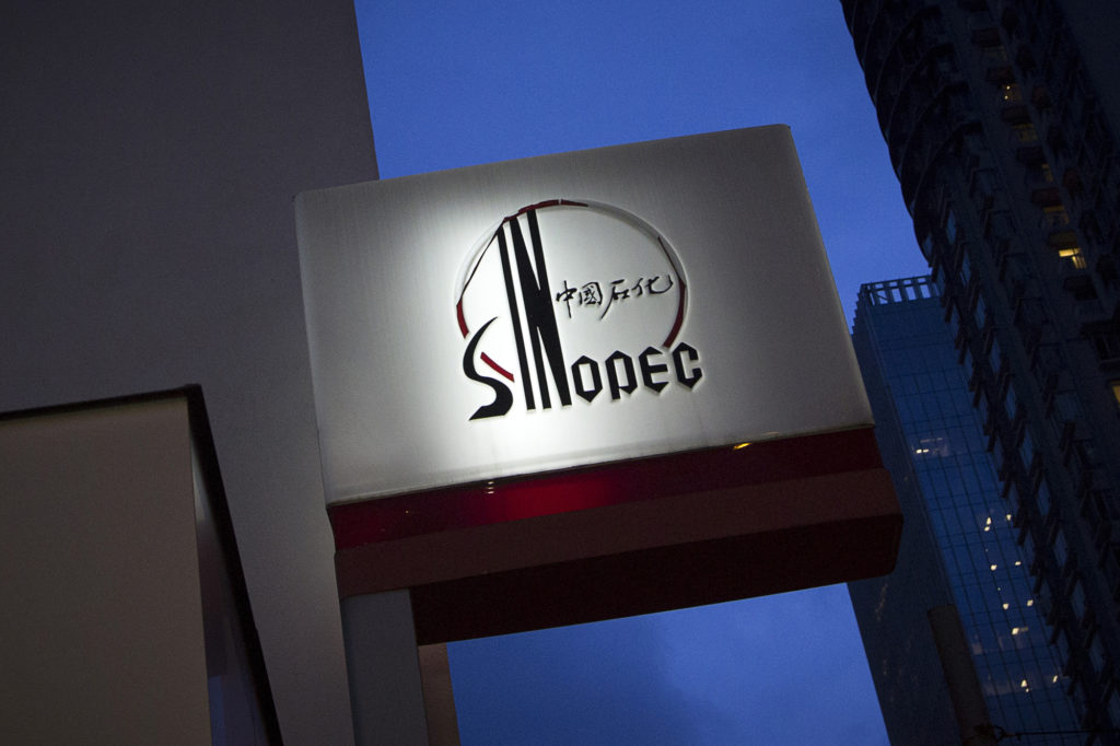 Signage for a China Petroleum & Chemical Corp. (Sinopec) gas station stands illuminated at dusk in Hong Kong, China, on Tuesday, Aug. 22, 2017. Sinopec is scheduled to report second-quarter results on Aug. 25. Photographer: Vivek Prakash/Bloomberg