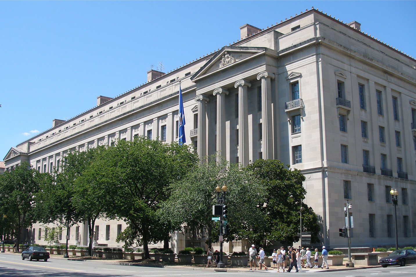 Building with columns and trees in front