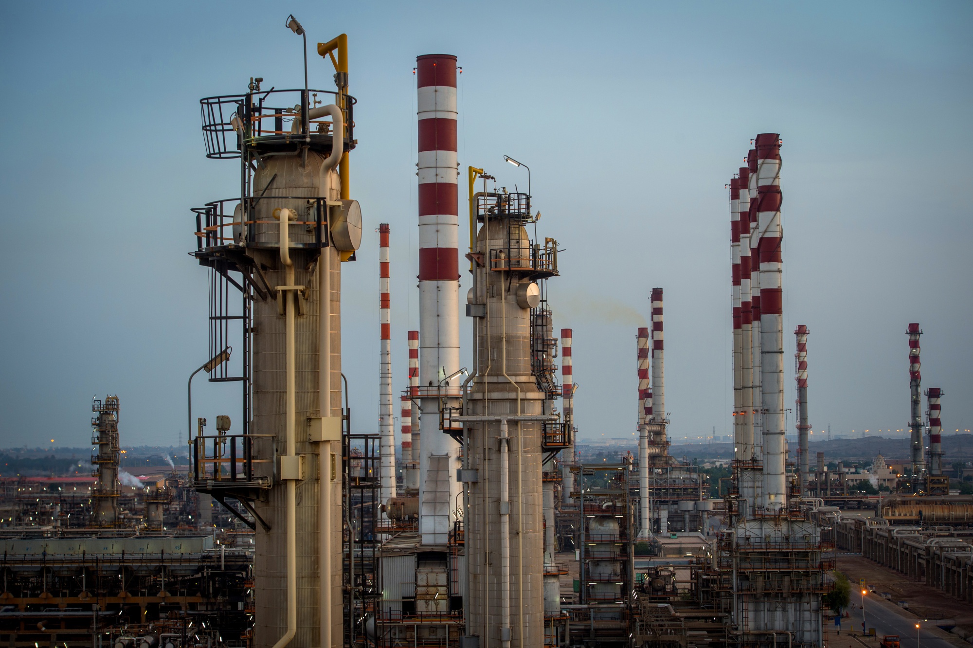 Cracking towers and chimneys stand at the processing plant at the Persian Gulf Star Co. (PGSPC) gas condensate refinery in Bandar Abbas, Iran, on Wednesday, Jan. 9. 2019. The third phase of the refinery begins operations next week and will add 12-15 million liters a day of gasoline output capacity to the plant, Deputy Oil Minister Alireza Sadeghabadi told reporters. Photographer: Ali Mohammadi/Bloomberg