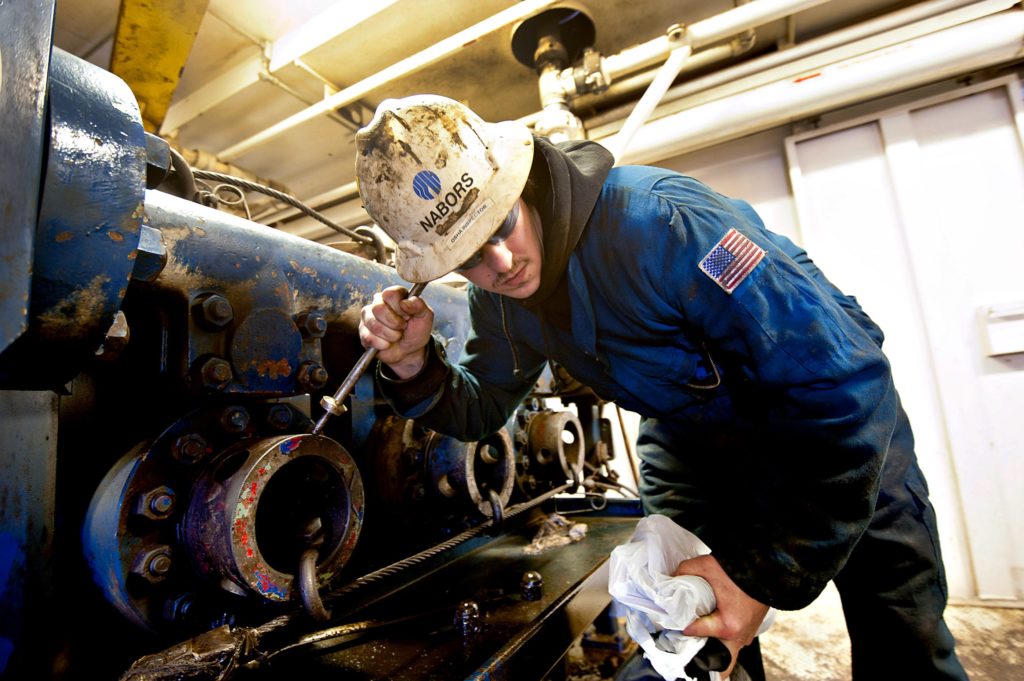 Nabors Industries Ltd. driller Zach Omeara uses a metal rod to listen to the internal operation of a drilling fluid circulation pump during a walk-through of a Nabors crude oil drill rig contracted by Fidelity Exploration & Production Company, a subsidiary of MDU Resources Group Inc., outside New Town, North Dakota, U.S., on Saturday, Feb. 11, 2012.  Photographer: Daniel Acker/Bloomberg