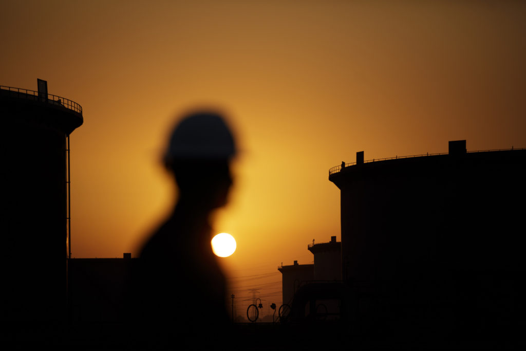 The sun sets over crude oil storage tanks at the Juaymah tank farm, operated by Saudi Aramco, in Ras Tanura, Saudi Arabia. Photographer: Simon Dawson/Bloomberg